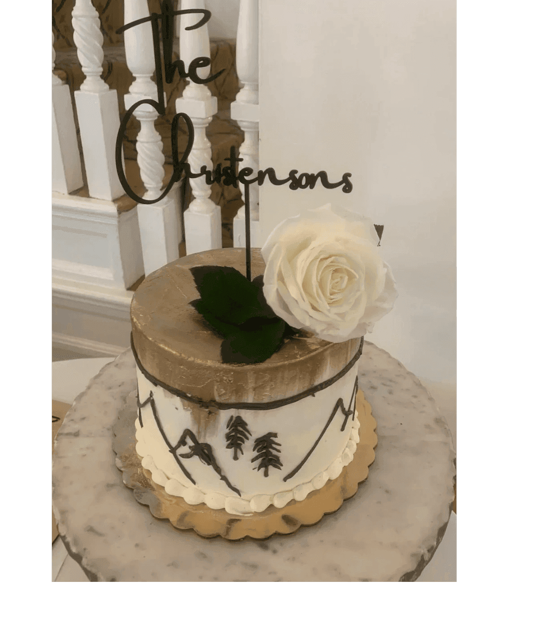White buttercream cake with a white rose and green sprigs