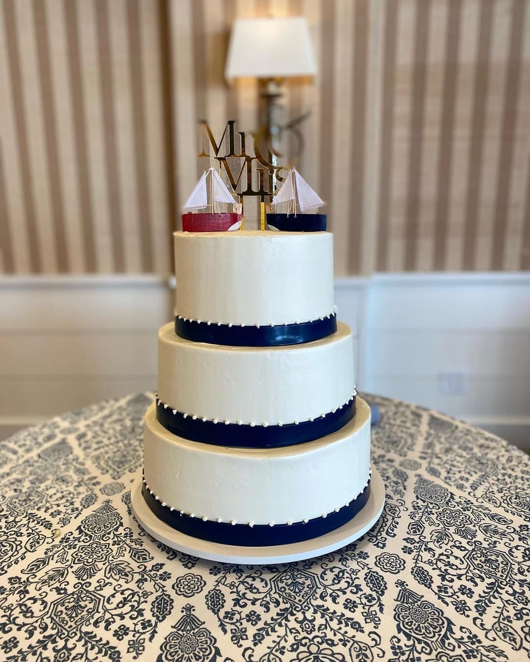 Tiered wedding cake banded with navy stripes