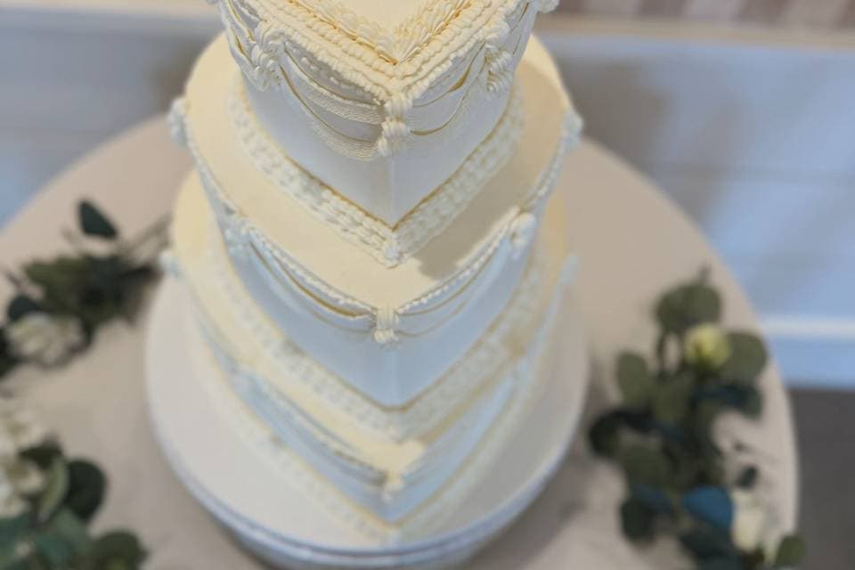 White wedding cake with draped, pleated fondant
