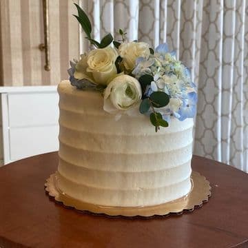 Single-tier combed buttercream cake with white roses