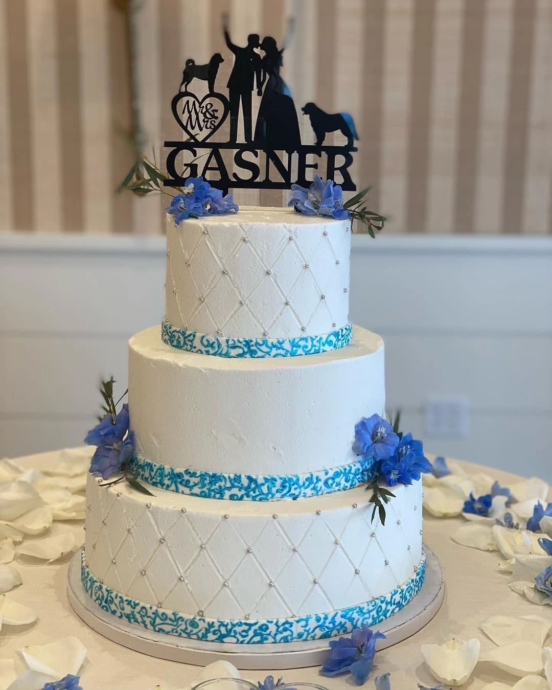 Tiered white wedding cake with blue florals