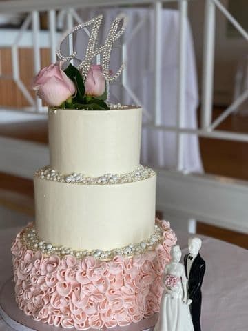 Two-tier cake with a textured blush base and fresh flowers