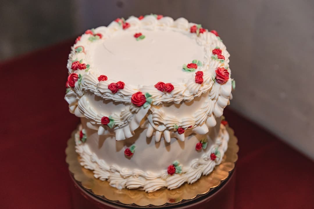 White cake ringed with a wreath of berries and flowers