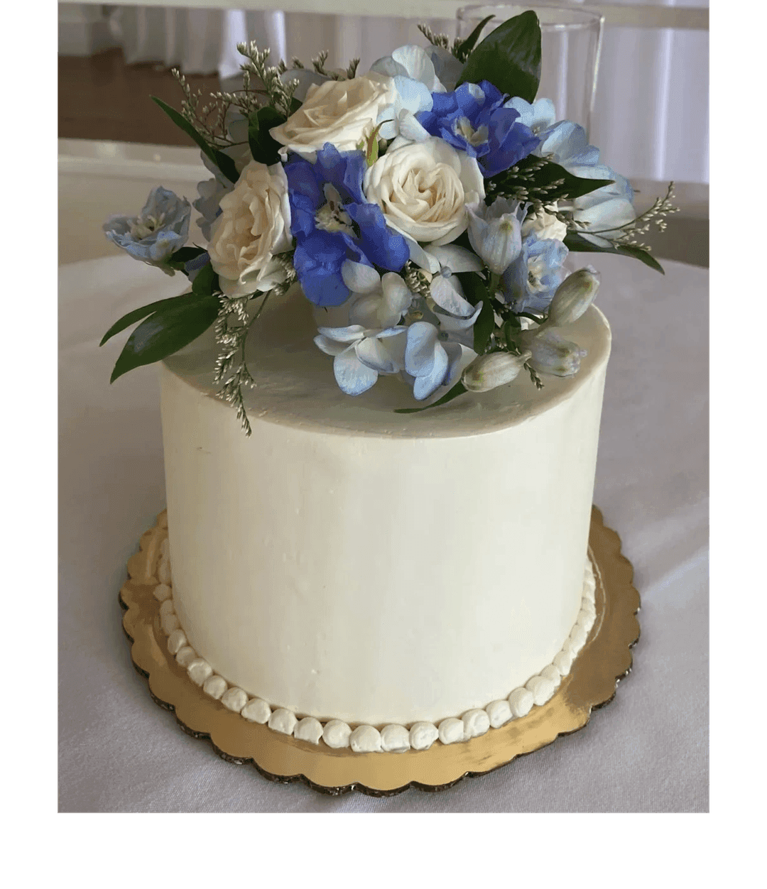 White wedding cake with blue and white blooms