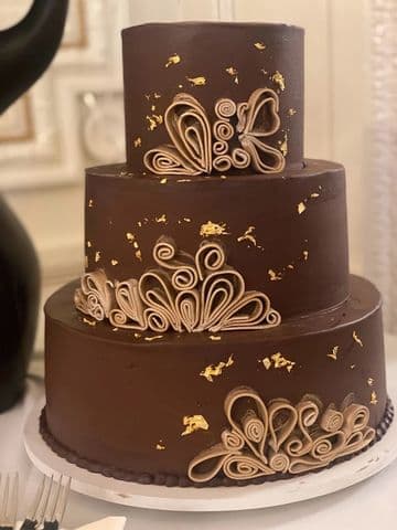Bronze two-tier cake finished with gold scrollwork piping