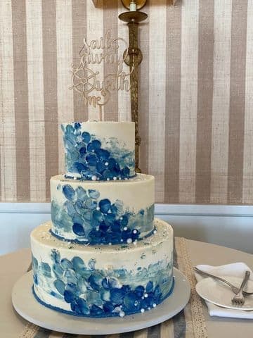Three-tier wedding cake hand-painted with blue watercolour hydrangea