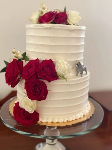 Combed white buttercream cake topped with deep red roses