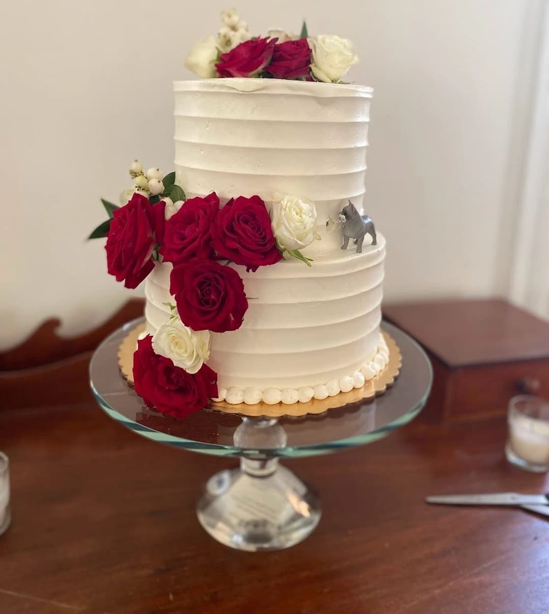 White tiered wedding cake with deep red roses