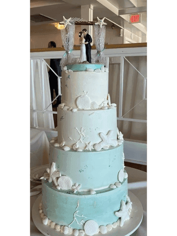 Pale mint tiered wedding cake with white blossoms