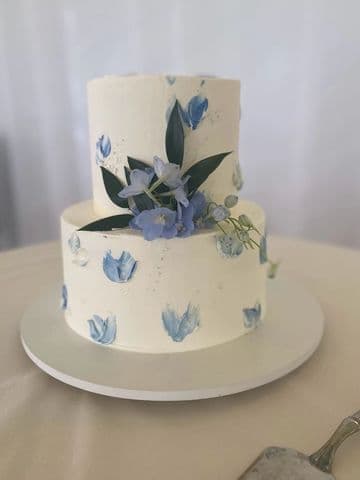 Two-tier cake hand-painted with blue and violet florals