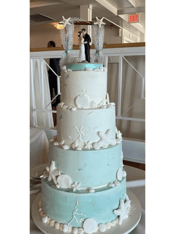 Three-tier soft mint wedding cake with white blossoms