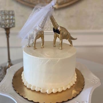Two-tier white cake with a stag figurine topper