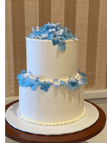 Two-tier white cake with blue sugar florals